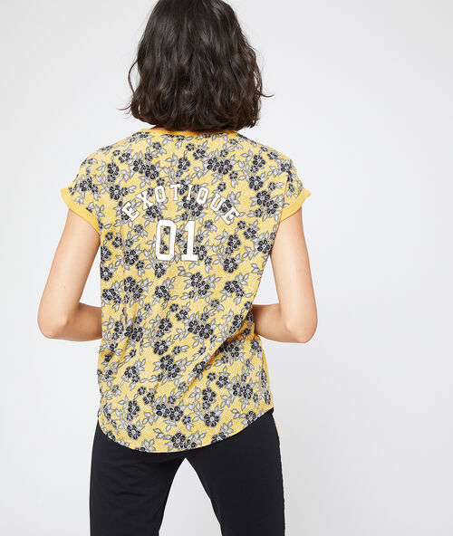 Tričko s květinov&yacute;mi z&aacute;dy, s n&aacute;pisem &bdquo;exotique&ldquo; okrov&aacute;.